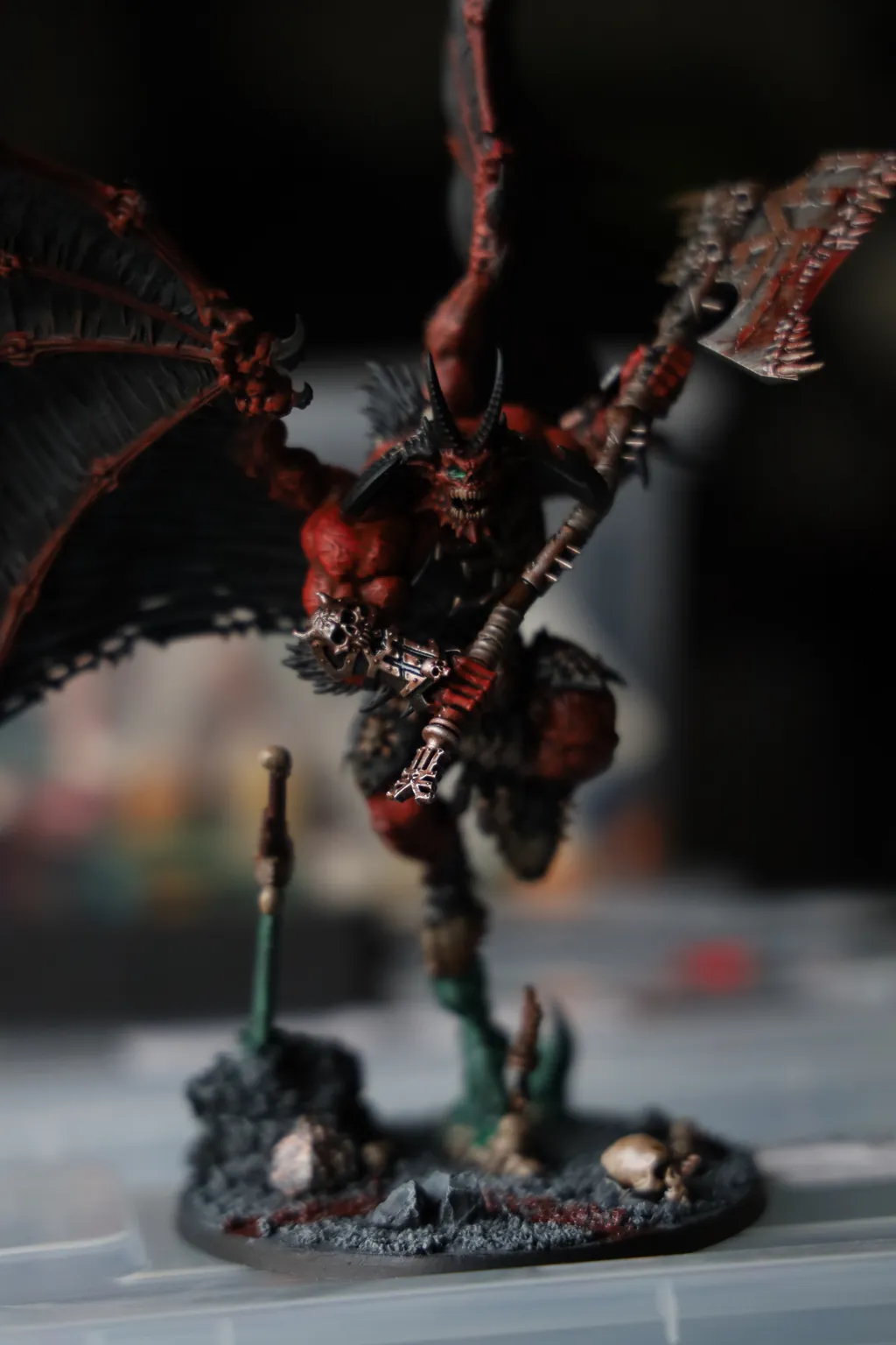 A painted miniature of a winged demon with an axe