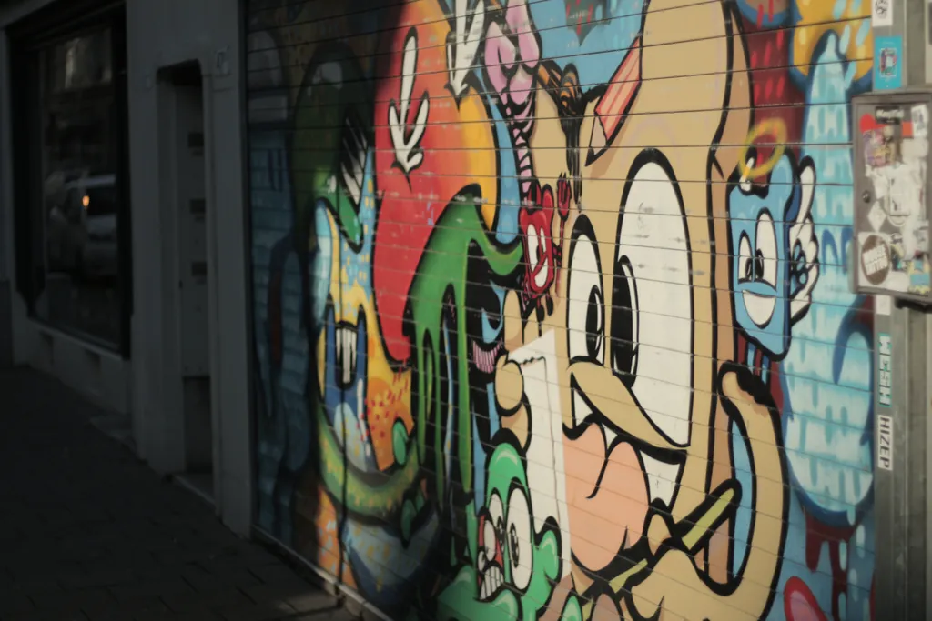 A colourful graffiti mural of cartoon figures on a shop shutter
