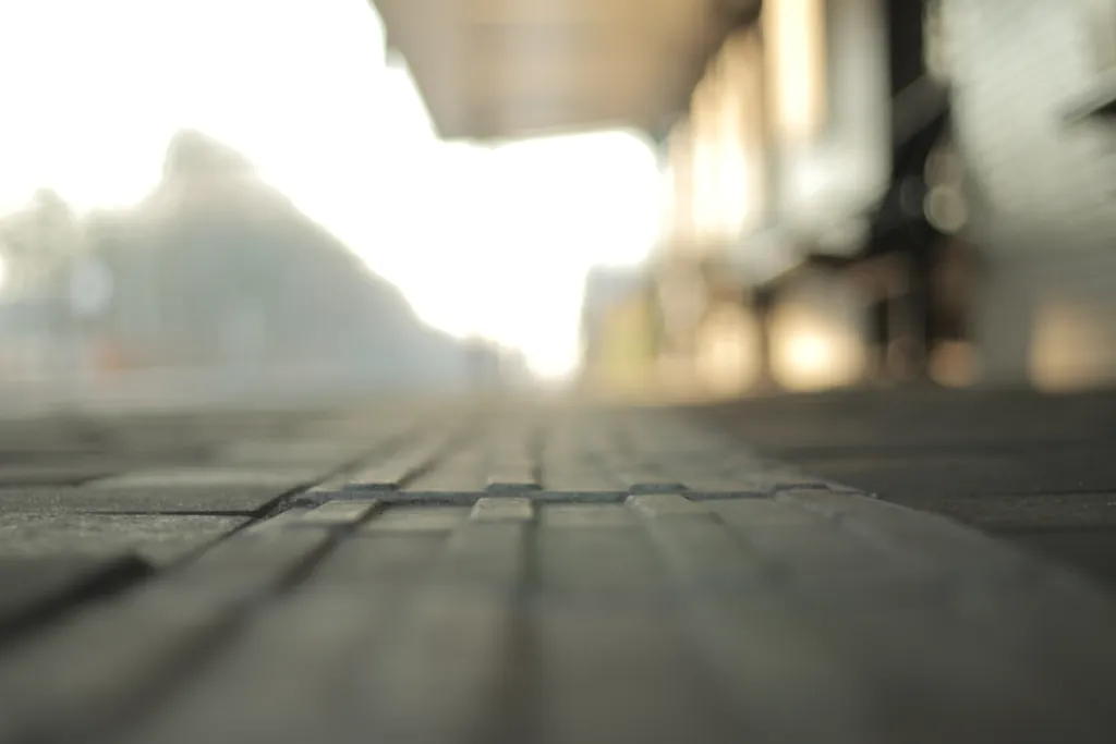 Paving stones seen from ground level, with a blurred street in soft light